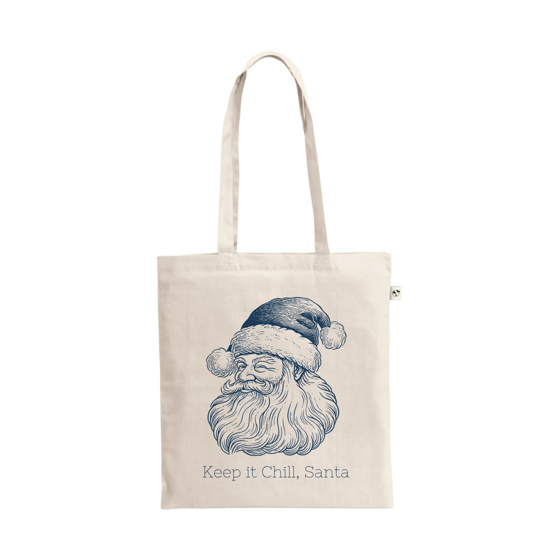 A natural cotton tote bag featuring a navy blue, vintage-style illustration of Santa Claus wearing a cap, with the text "Keep it Chill, Santa" printed underneath.